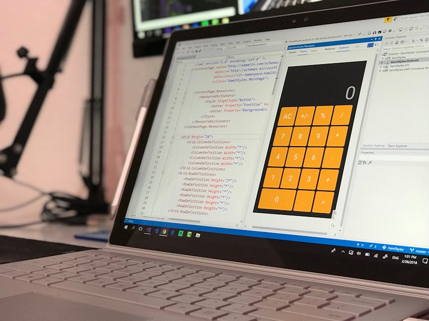 Close-up view of a laptop with a silver keyboard, displaying a spreadsheet with code on the left and a large, orange calculator interface on the right. The screen shows numerical buttons, plus and min